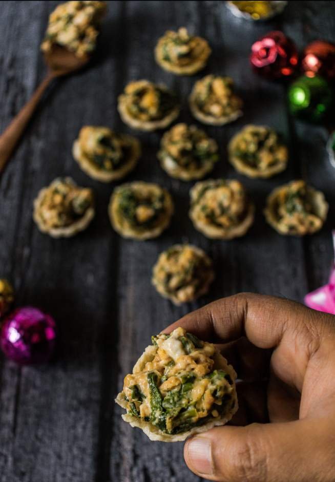 holding one Cheesy Spinach Dip Puff Bites - Easy and Cute Christmas Appetizer