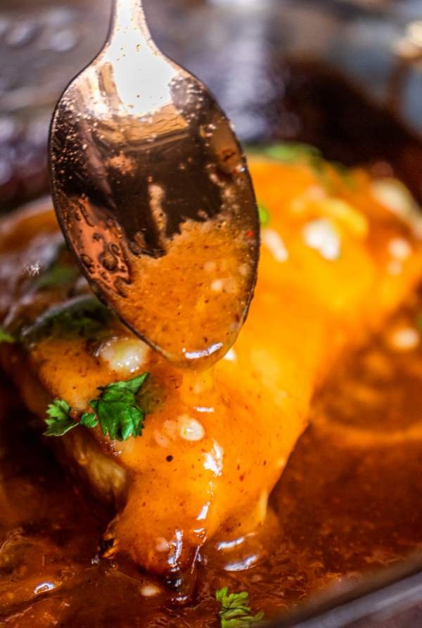 pouring honey mustard sauce over chicken breast using a spoon