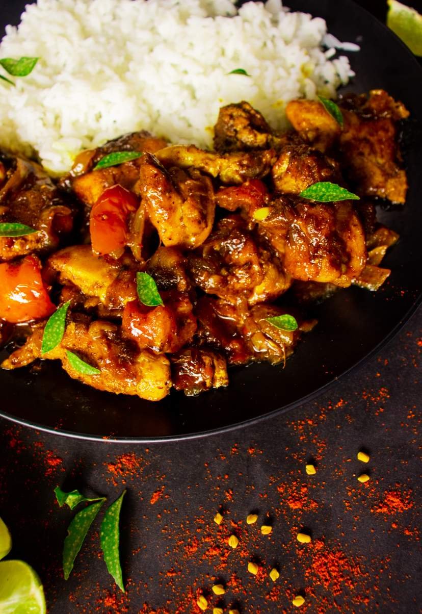 chicken in a black plate with white rice