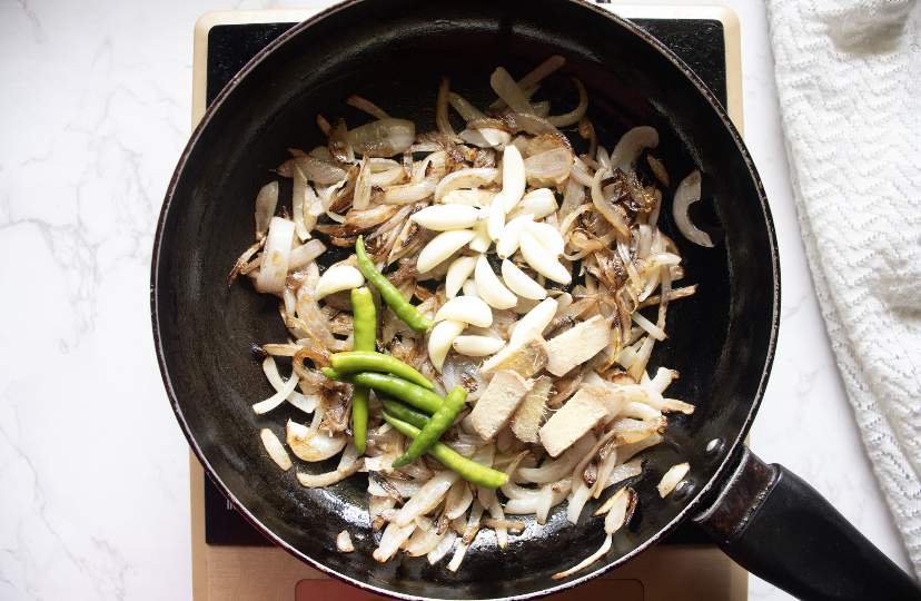 added garlic cloves green chilies and ginger to the skillet
