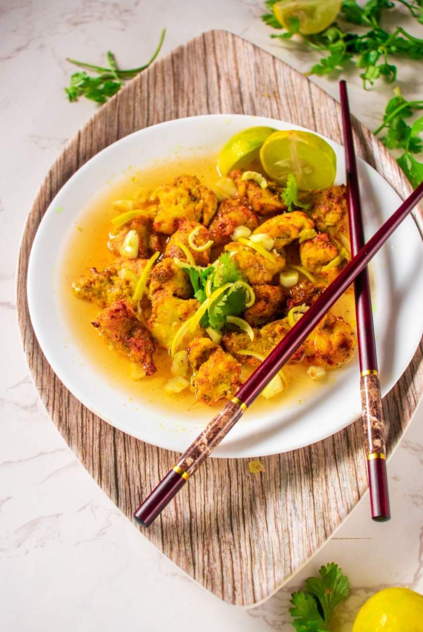 keto lemon chicken on a white plate with chopsticks