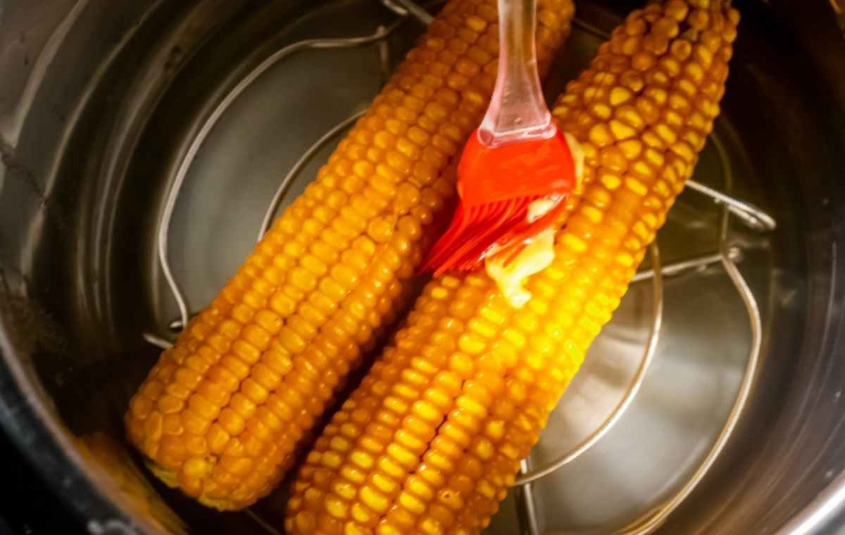 spreading butter over corn