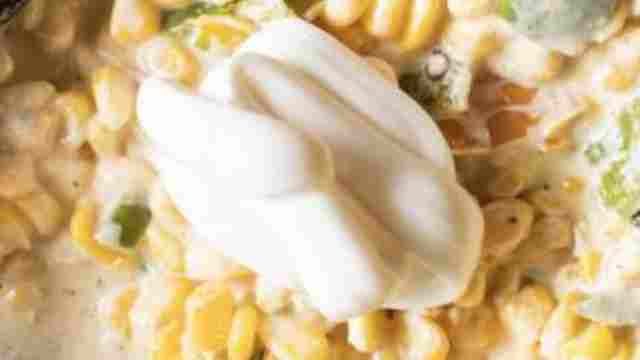 adding cream cheese to the corn
